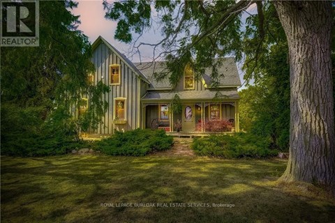 A house with a lawn and trees in front of it.