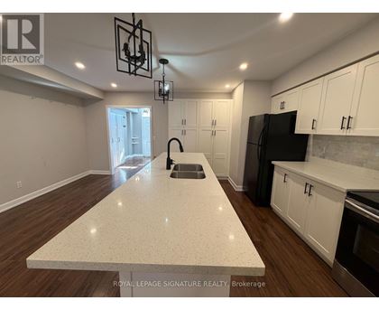 A kitchen with a white countertop and wooden floors.