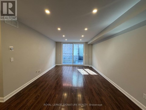 A room with wooden floors and a window in Brokerage.