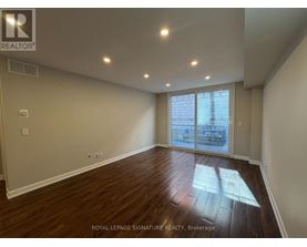 A room with wooden flooring and a sliding glass door.