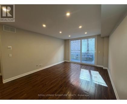 A room with wooden flooring and a sliding glass door.