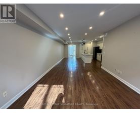 A long, empty hallway with wooden floors and white walls.