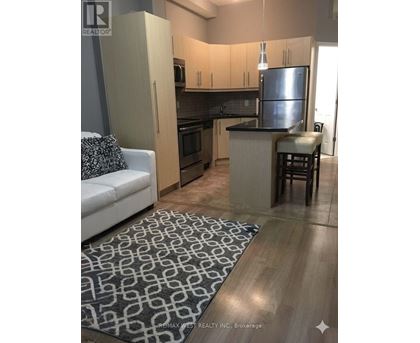 A kitchen with a refrigerator, microwave, and oven.