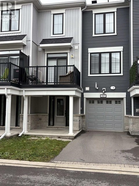 A modern two-story residential building with a balcony on the first floor.