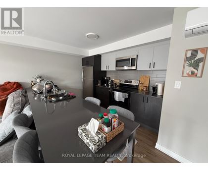 A kitchen with a black countertop and a grey couch.