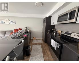A kitchen with a black counter top and a white fridge.