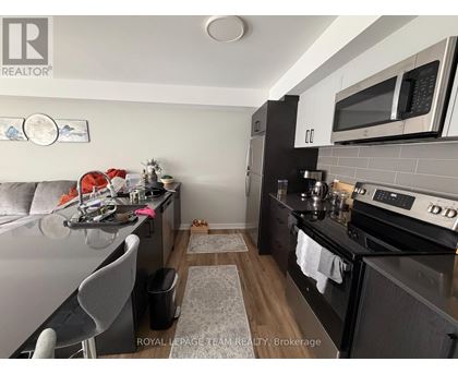 A kitchen with a black counter top and a white fridge.