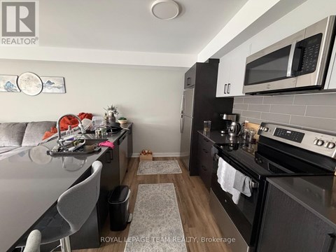 A kitchen with a black counter top and a white fridge.