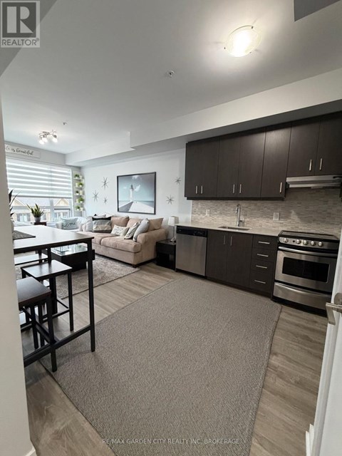 A modern kitchen with dark brown cabinets and a grey rug on the floor.