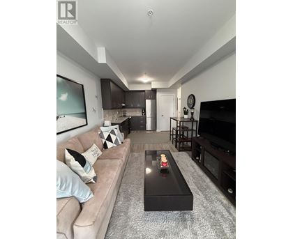 A modern living room with a beige couch and a black coffee table.