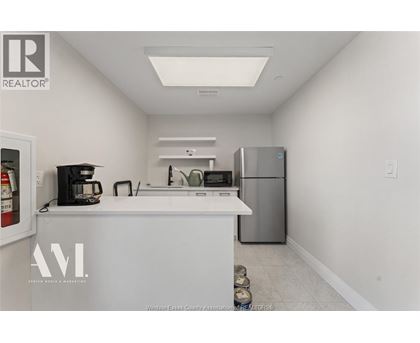 A kitchen with white cabinets and a white counter top.