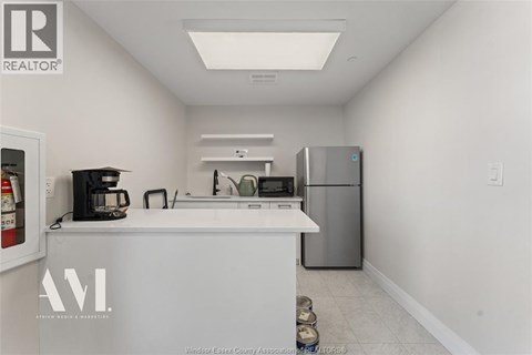 A kitchen with white cabinets and a white counter top.