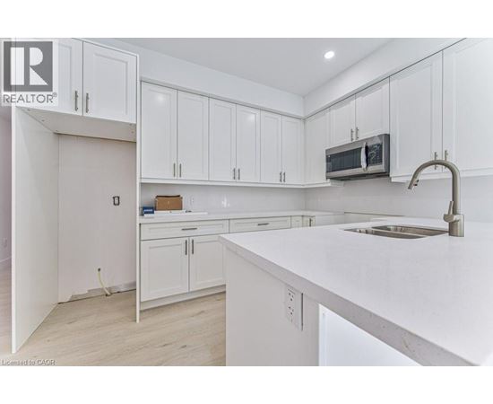 A kitchen with white cabinets and a white countertop.