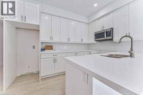 A kitchen with white cabinets and a white countertop.