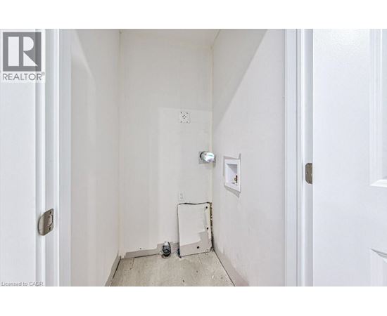 A white hallway with a door on the left and a door on the right.