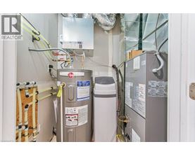 A view of a room with a refrigerator, a water heater, and a furnace.