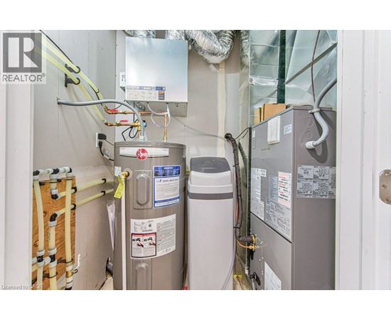 A view of a room with a refrigerator, a water heater, and a furnace.