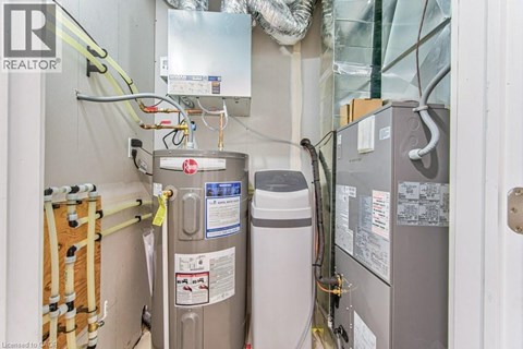 A view of a room with a refrigerator, a water heater, and a furnace.