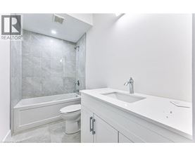 A white bathroom with a tub, toilet and sink.
