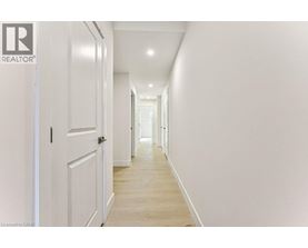A long hallway with white walls and wood floors.
