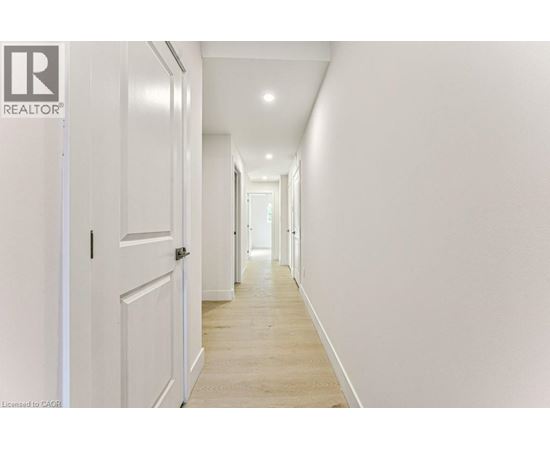 A long hallway with white walls and wood floors.
