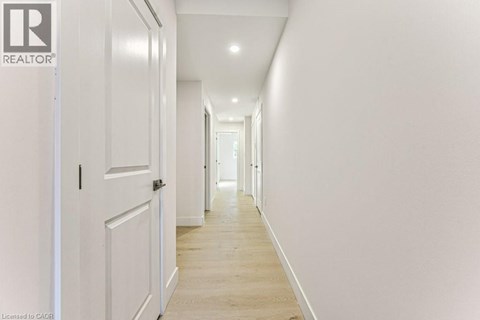 A long hallway with white walls and wood floors.