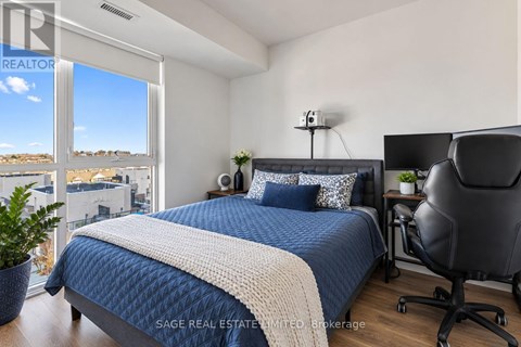 A bedroom with a large bed and a chair.