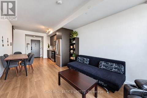 A living room with a black couch and a wooden coffee table.