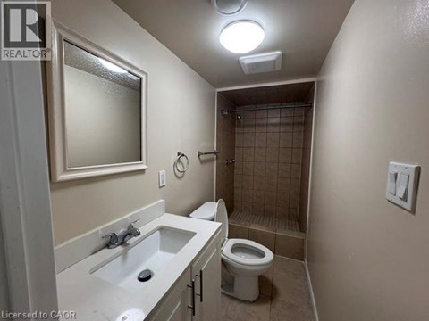 A bathroom with a toilet, sink, and shower.