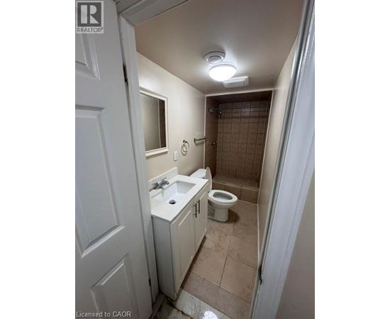 A bathroom with a toilet, sink, and shower.