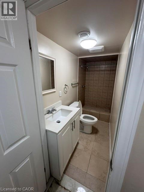 A bathroom with a toilet, sink, and shower.