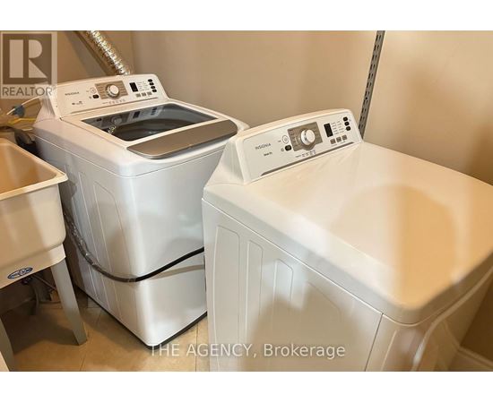 A white washing machine and dryer are in a laundry room.