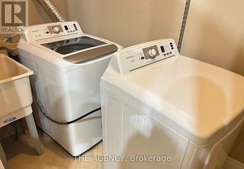 A white washing machine and dryer are in a laundry room.