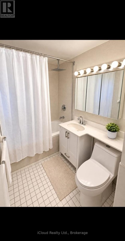 A white bathroom with a toilet, sink, and mirror.