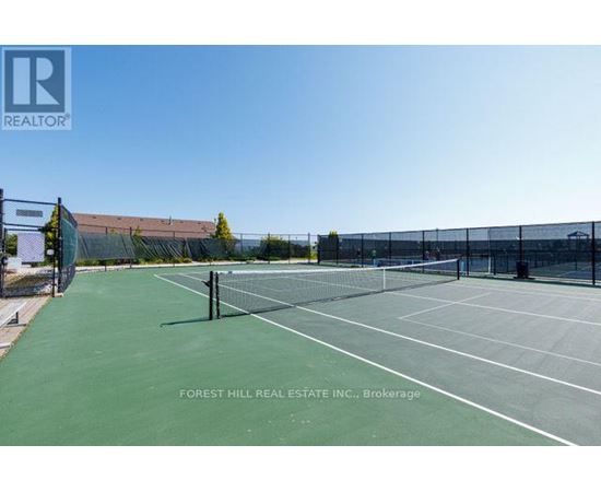 A tennis court with a Forest Hill Real Estate Inc. sign in the background.