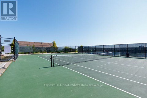A tennis court with a Forest Hill Real Estate Inc. sign in the background.