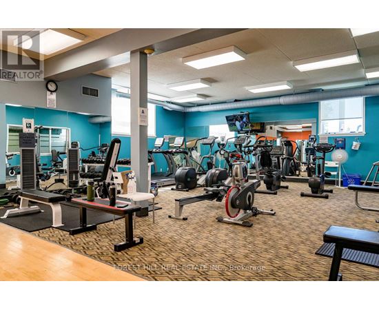 A gym with a variety of equipment including treadmills, weights, and exercise machines.