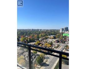 A view from a balcony overlooking a city with a highway and buildings.
