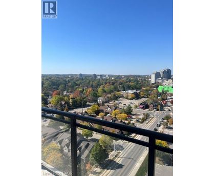A view from a balcony overlooking a city with a highway and buildings.