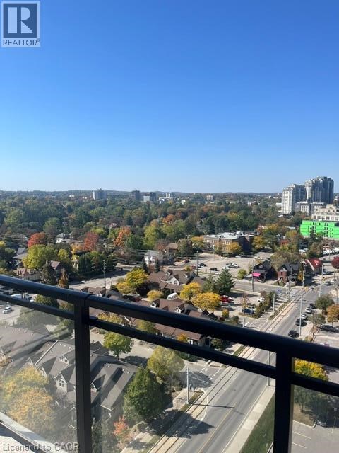 A view from a balcony overlooking a city with a highway and buildings.