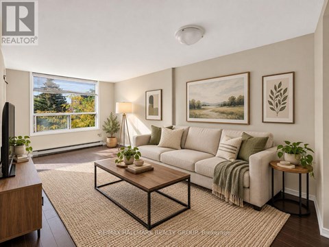 A living room with a couch, coffee table, and two potted plants.