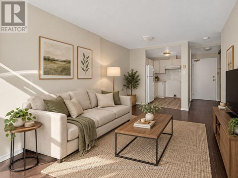 A living room with a white couch, a coffee table, and a lamp.