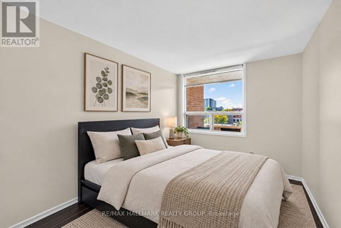 A bedroom with a large bed and a window overlooking a cityscape.
