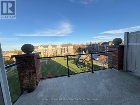 A balcony with a view of apartment buildings and a clear sky.
