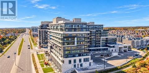 A large, modern building with the words "Mark Realtor" on it is situated on a street with cars and other buildings in the background.