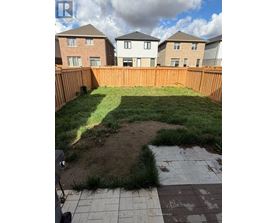 A backyard with a wooden fence and a small patch of dirt in the middle.