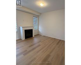 A room with a fireplace and wood flooring.