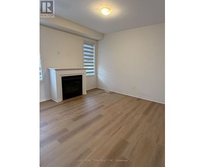 A room with a fireplace and wood flooring.