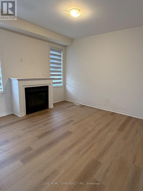A room with a fireplace and wood flooring.