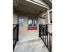 A house with a red door and a black railing.